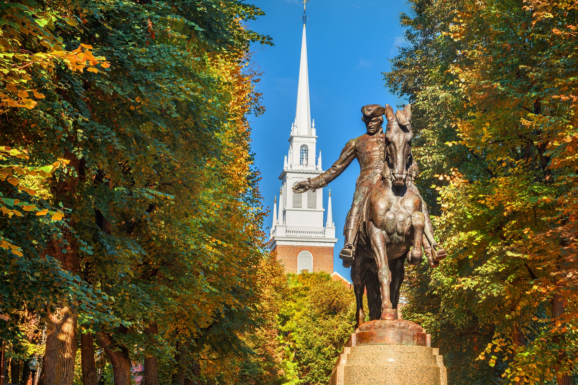 A tour of the Freedom trail in Boston featuring a bronze statue of paul revier surrounded by autumn foliage